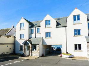 a large white house with a parking lot at The Clamshell in Isle of Whithorn