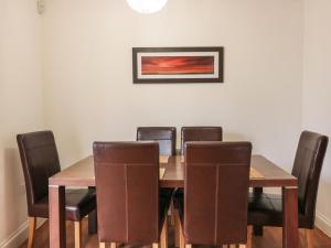 uma sala de jantar com uma mesa de madeira e cadeiras em 4 Bredon Court em Newquay