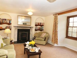 sala de estar con sofá y chimenea en Westroose Farm House, en Otterham