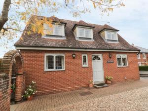 a red brick house with a white door at The Lodge off High Street in Hadleigh