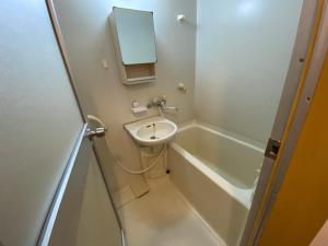 a small bathroom with a sink and a bath tub at Second Habor Beach House in Naha