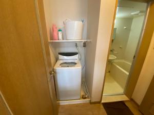 a washer and dryer in a small bathroom at Second Habor Beach House in Naha