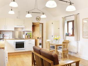una cucina e una sala da pranzo con tavolo e sedie di Acorn Cottage 1 a Petton