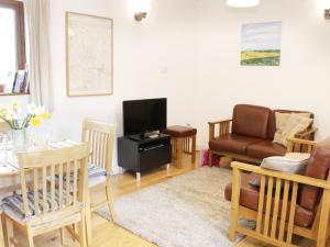 a living room with a couch and a table at Acorn Cottage 1 in Petton