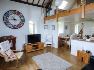 a living room with a large clock on the wall at Eglwys St Cynfil in Pwllheli