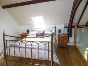 a bedroom with a metal bed and a night stand at Eglwys St Cynfil in Pwllheli