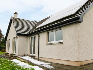 a house with a solar roof with snow on the ground at Glaven in Bonar Bridge