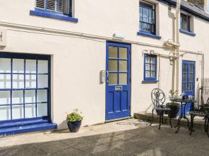 a house with blue doors and a table and chairs at The Compass in Swanage