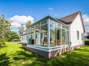 una casa con puertas de cristal en un patio en Tigh Na Sith, en Aultbea