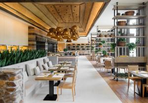 三亚 三亚1Hotel海棠湾阳光壹酒店（可持续发展理念）的有桌椅和酒吧的餐厅