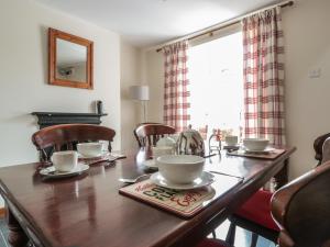 a wooden table with chairs and a tea set on it at 25 Parragate Road in Cinderford