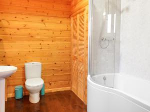a bathroom with a toilet and a bath tub at Holly Lodge in Bodmin +5 photos