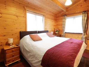 a bedroom with a bed in a wooden cabin at Holly Lodge in Bodmin