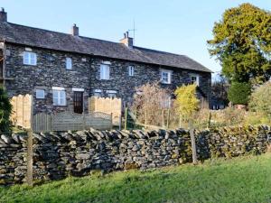 a stone house with a stone fence in front of it at The Hayloft in Kendal