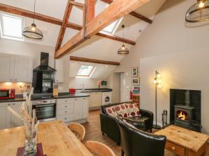 a kitchen and dining room with a table and a wood stove at Hen Blas in Aberdaron