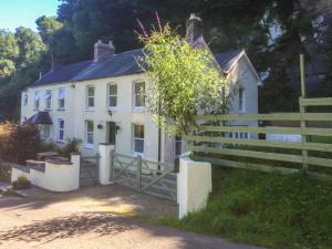 a white house with a fence in front of it at Teifi House in Cilgerran