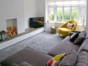 a living room with a couch and a tv at Llechwedd in Dolgellau