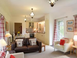 sala de estar con sofá y cocina en Old Mill Cottage, en Camelford