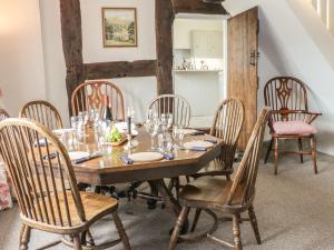 a dining room with a wooden table and chairs at Lower Hodre in Bucknell