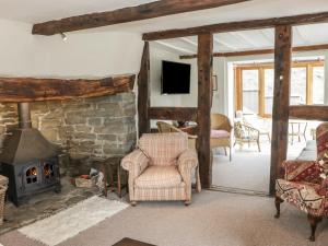 a living room with a stone fireplace and chairs at Lower Hodre in Bucknell