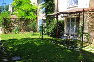 a patio with a table and chairs in a yard at Gte De Charme Le Cdre in Baron