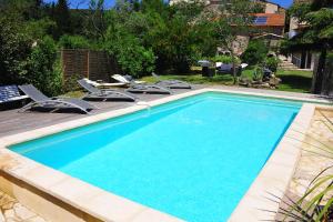 a swimming pool with lounge chairs and a swimming pool at Gte De Charme Le Cdre in Baron