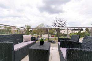 a patio with wicker chairs and a couch and a table at Perła Rentyear Apartments in Gdańsk