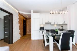 a kitchen and dining room with a table and chairs at Perła Rentyear Apartments in Gdańsk