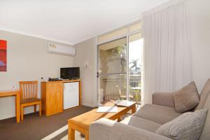 a living room filled with furniture and a tv at Mandurah Motel and Apartments in Mandurah