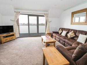 a living room with a couch and a tv at 2 Y Bae in Trearddur