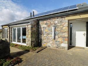 a stone house with a door and a garage at Buttermere in Cockermouth