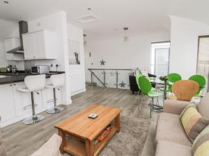 a living room with a couch and a table at 3 Marina View in Pwllheli