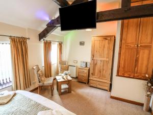 una camera da letto con un letto e una TV a parete di Juniper Cottage ad Ambleside