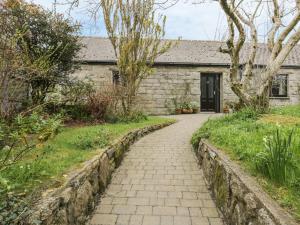a stone house with a walkway in front of it at Brunnion Cottage in Hayle +6 photos