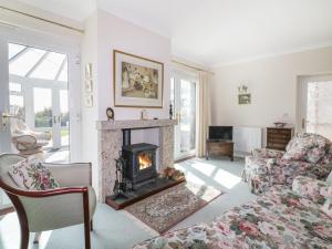 a living room with a fireplace and a couch at Sheila's Cottage in Penryn