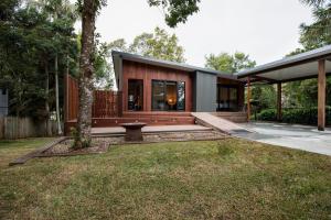 a modern house with a tree in the yard at Springbrook25 Pet friendly House in Springbrook