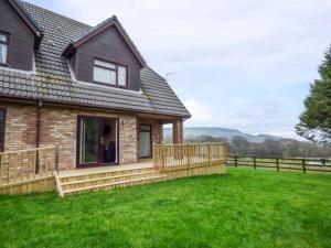 a house with a fence and a grass yard at Cwm Gran Meadows in Llanharan
