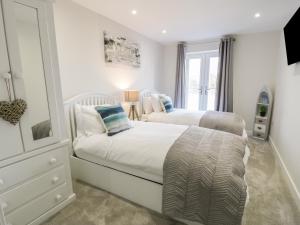a bedroom with two beds and a mirror at 6 Bay View in Benllech
