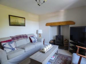 a living room with a couch and a wood stove at Pretoria in Coverack