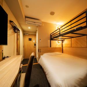 a hotel room with a bed and a bunk bed at Super Hotel Nagaizumi Numazu Inter in Nagaizumi