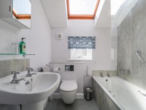 a bathroom with a sink and a toilet and a tub at Swinside Cottage in Keswick
