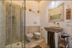 uma casa de banho com um WC, um lavatório e um chuveiro em La perla bianca em Ostuni