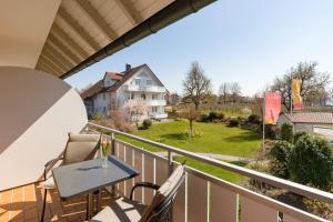a balcony with a table and chairs and a house at Hotel Gästehaus Zürn in Wasserburg