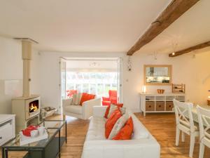 a living room with a white couch and a fireplace at Pottery Barn in Branscombe