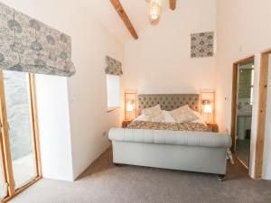 a bedroom with a bed and a large window at Wern Olau Cottage in Caernarfon