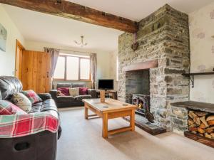 a living room with a stone fireplace and a couch at Blaen Henllan in Aberedw