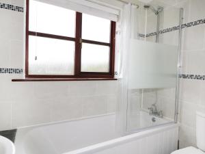 ein Badezimmer mit Badewanne und Fenster in der Unterkunft Seal Cottage in Woolacombe + 19 Fotos