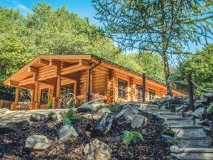 eine Blockhütte im Wald mit einem Steingang davor in der Unterkunft Wilderness Lodge in Shelve