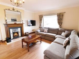 a living room with a couch and a fireplace at Gweld y Môr in Colwyn Bay