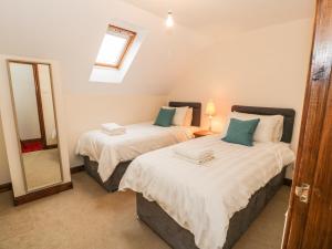 two beds in a small room with a mirror at Gweld y Môr in Colwyn Bay